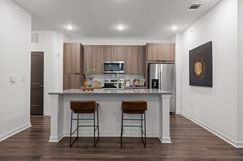 A modern kitchen with a bar stool in front of the island.
